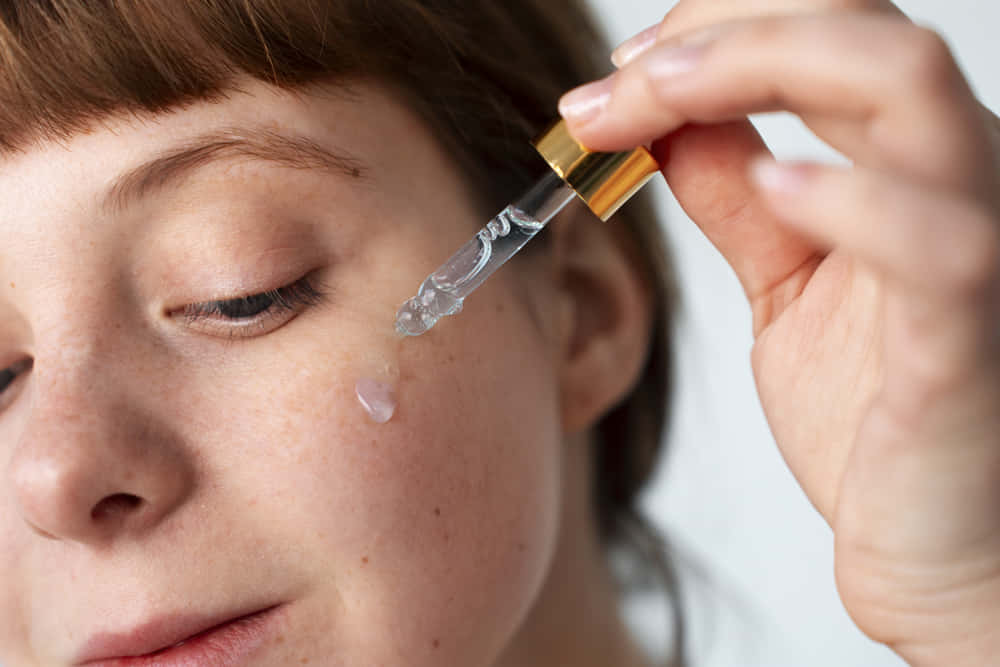 Ácido salicílico. Mujer aplicando serum sobre el rostro.