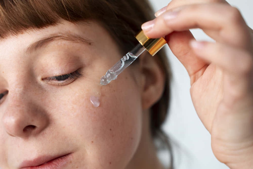 Ácido salicílico. Mujer aplicando serum sobre el rostro.